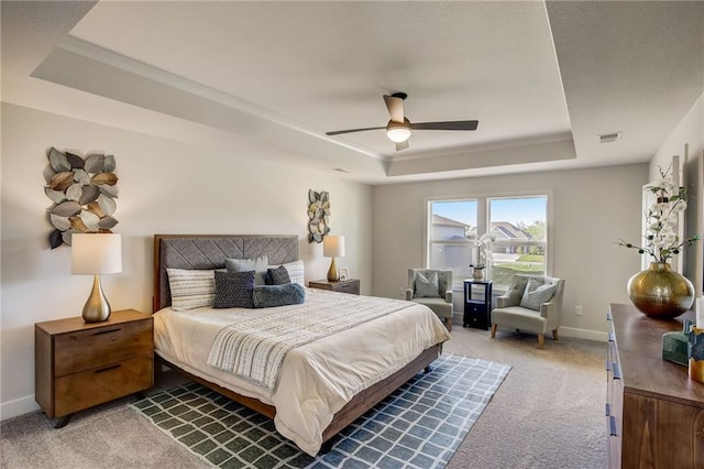 bedroom with visible vents, carpet, baseboards, and a tray ceiling