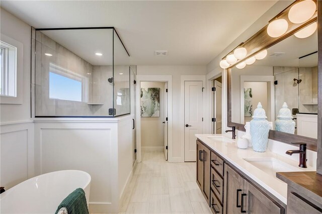 bathroom featuring a freestanding tub, a sink, and a stall shower