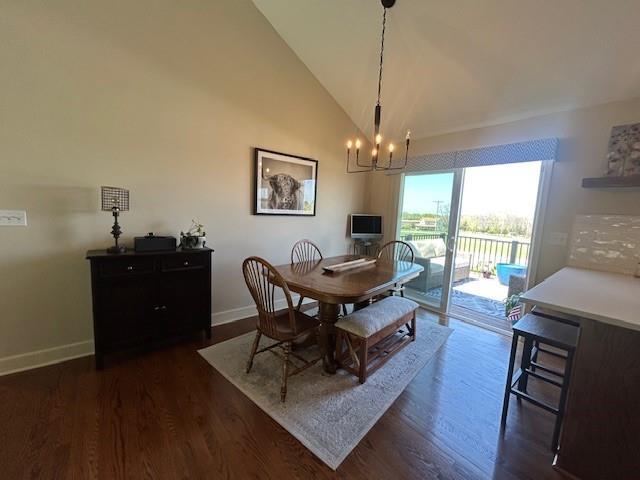 dining room featuring baseboards, dark wood-style floors, high vaulted ceiling, and an inviting chandelier