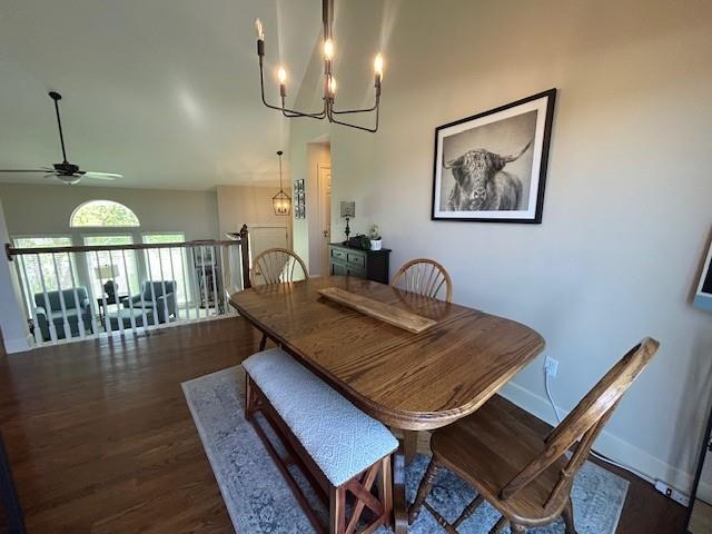 dining room with dark wood-style flooring, baseboards, and ceiling fan with notable chandelier