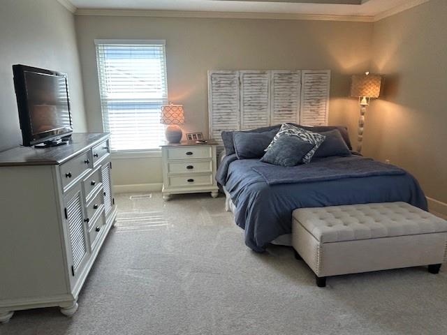 bedroom featuring crown molding, baseboards, and carpet flooring