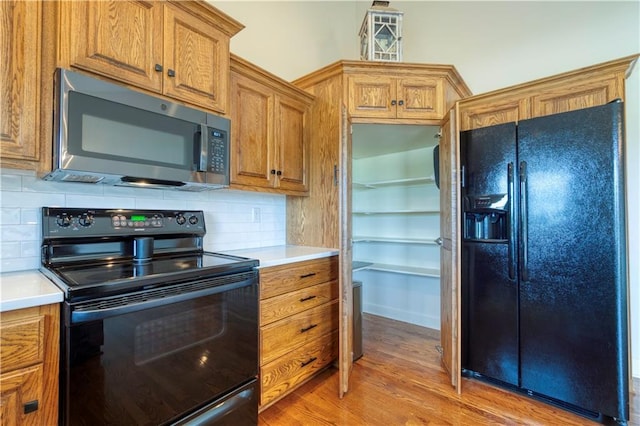 20534 W 199th Ter, Spring Hill, KS 66083 - kitchen featuring black appliances, brown cabinetry, light countertops, and backsplash