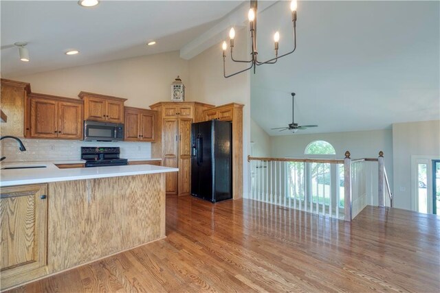 20534 W 199th Ter, Spring Hill, KS 66083 - kitchen featuring black appliances, plenty of natural light, tasteful backsplash, light wood-type flooring, and high vaulted ceiling