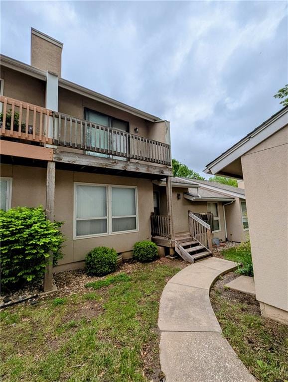exterior space with stucco siding and a balcony