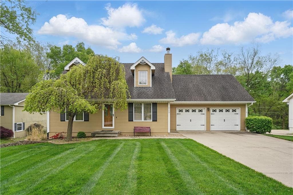 2709 NW Powderhorn Dr, Kansas City, MO 64154 - new england style home featuring a garage, a front lawn, a chimney, and concrete driveway