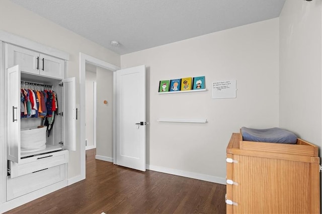 bedroom featuring baseboards and dark wood-type flooring