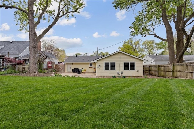 rear view of property featuring a fenced backyard, a gate, a lawn, and a patio area