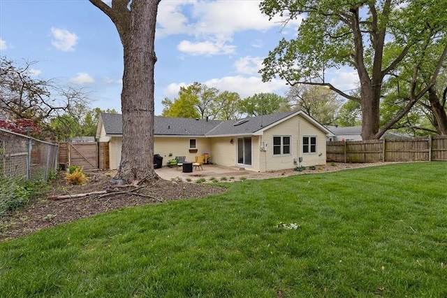 rear view of property featuring a patio, a fenced backyard, and a lawn