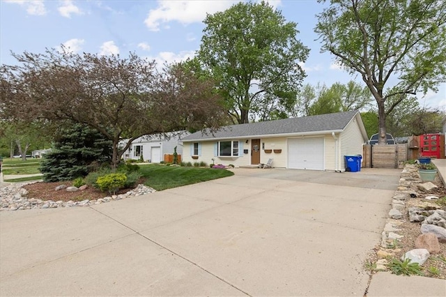 ranch-style home featuring fence, an attached garage, driveway, and a front lawn