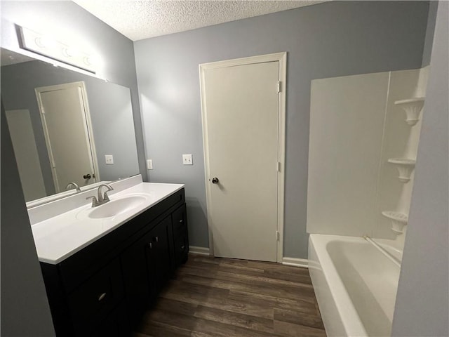 full bath featuring vanity, a textured ceiling, and wood finished floors