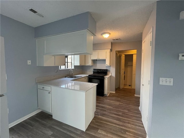 kitchen featuring visible vents, a peninsula, black electric range oven, dark wood-style floors, and a sink