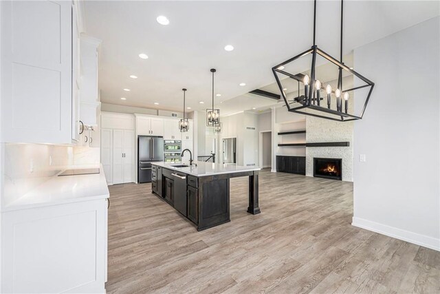 10075 NW Hillsboro Rd, Platte City, MO 64079 - kitchen with stainless steel appliances, a chandelier, open floor plan, light countertops, and light wood-style floors