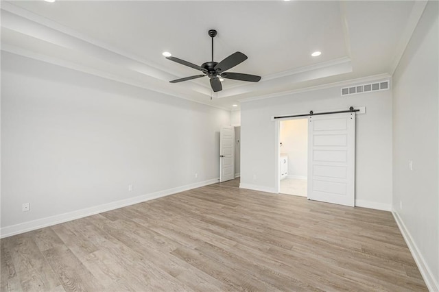 10075 NW Hillsboro Rd, Platte City, MO 64079 - unfurnished bedroom with a raised ceiling, a barn door, recessed lighting, light wood-style flooring, and ornamental molding