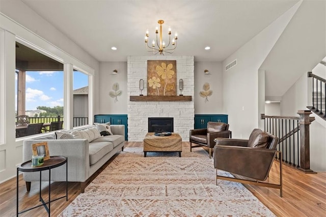 17163 S Laurelwood St, Olathe, KS 66062 - living area featuring wood finished floors, a chandelier, and a stone fireplace