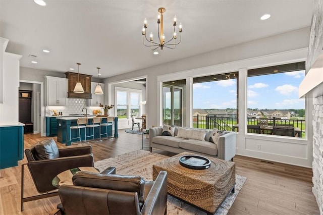 17163 S Laurelwood St, Olathe, KS 66062 - living room with a chandelier, light wood-style flooring, and recessed lighting