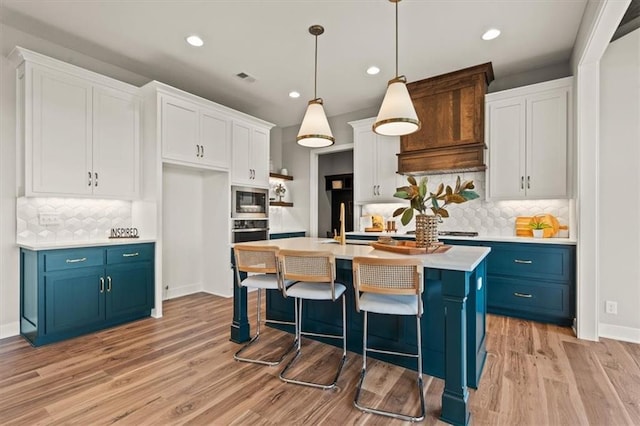 17163 S Laurelwood St, Olathe, KS 66062 - kitchen featuring blue cabinetry, stainless steel microwave, white cabinetry, light countertops, and recessed lighting