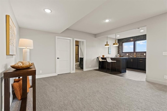 17163 S Laurelwood St, Olathe, KS 66062 - kitchen featuring light carpet, baseboards, recessed lighting, dark cabinetry, and hanging light fixtures