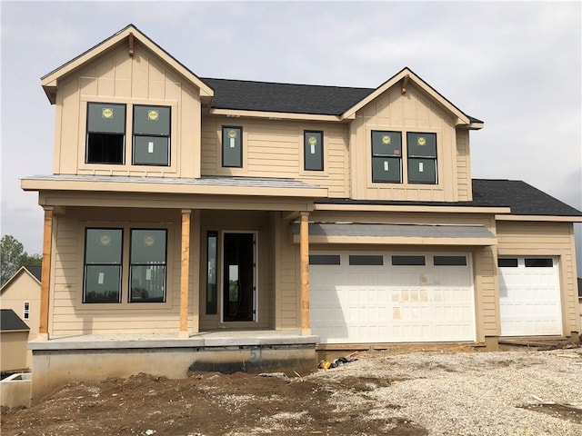 17163 S Laurelwood St, Olathe, KS 66062 - view of front of home with covered porch, board and batten siding, a garage, and gravel driveway