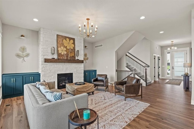 17163 S Laurelwood St, Olathe, KS 66062 - living area with a chandelier, stairway, wood finished floors, a stone fireplace, and recessed lighting