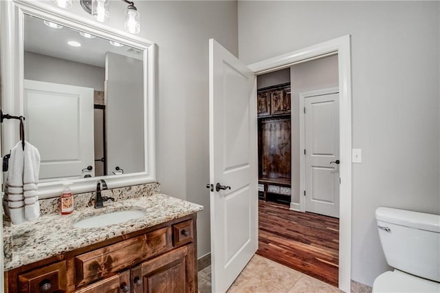 bathroom with vanity, baseboards, and toilet