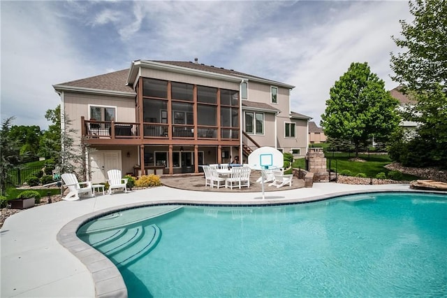 pool with a patio and fence