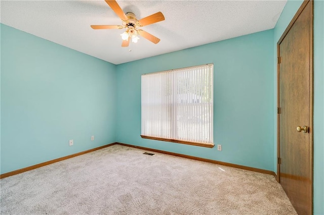 spare room featuring carpet flooring, a ceiling fan, baseboards, and a textured ceiling