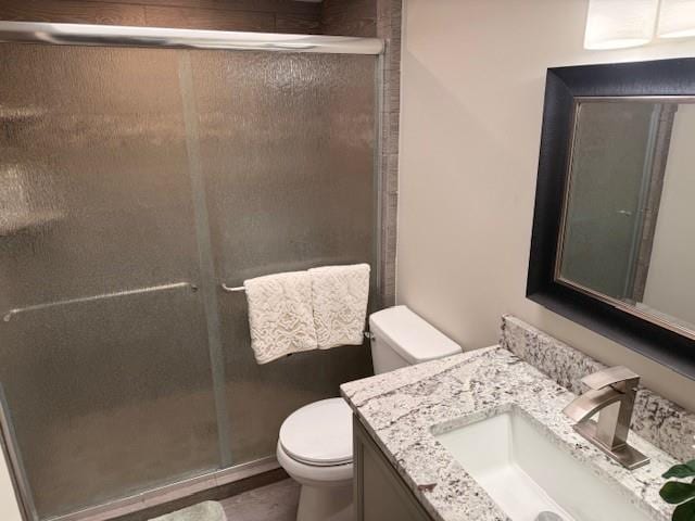 full bathroom featuring vanity, toilet, and a stall shower