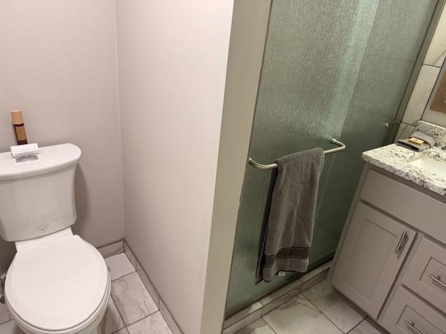 bathroom with vanity, toilet, and marble finish floor