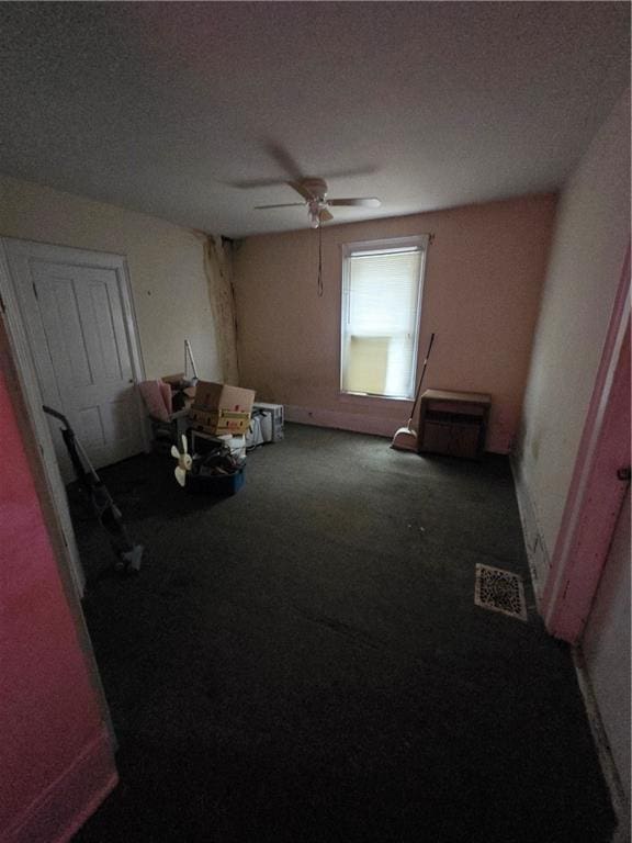 unfurnished room with visible vents, a ceiling fan, and carpet flooring