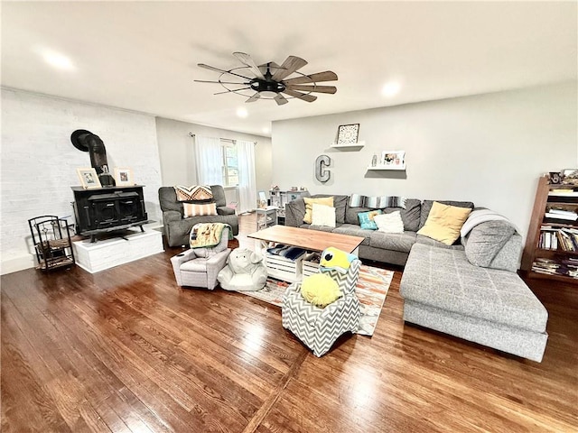 living area with recessed lighting, a wood stove, ceiling fan, and wood finished floors