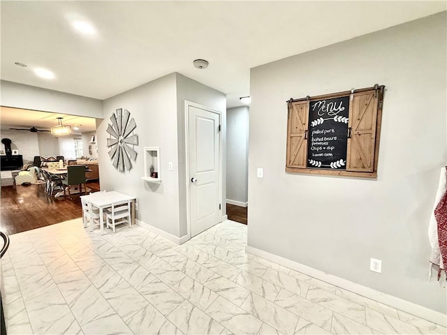 hall featuring baseboards, recessed lighting, and marble finish floor