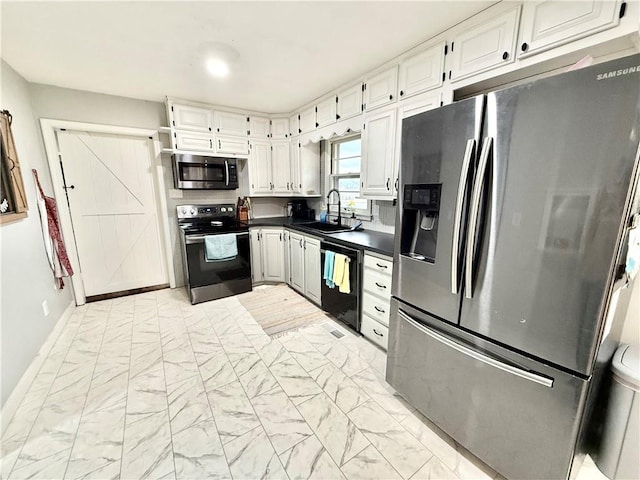 kitchen with appliances with stainless steel finishes, dark countertops, a sink, white cabinets, and marble finish floor