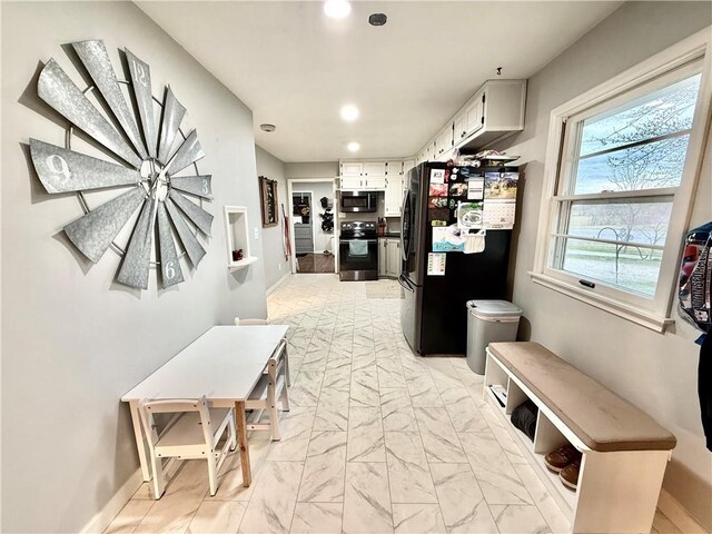 hallway featuring baseboards, recessed lighting, and marble finish floor