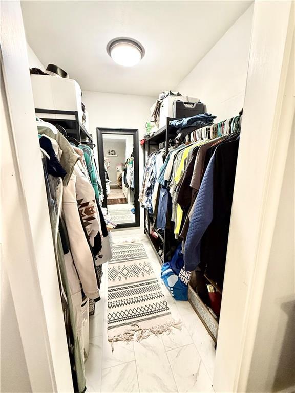 walk in closet with marble finish floor