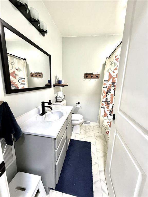 full bath with vanity, marble finish floor, toilet, and a shower with curtain