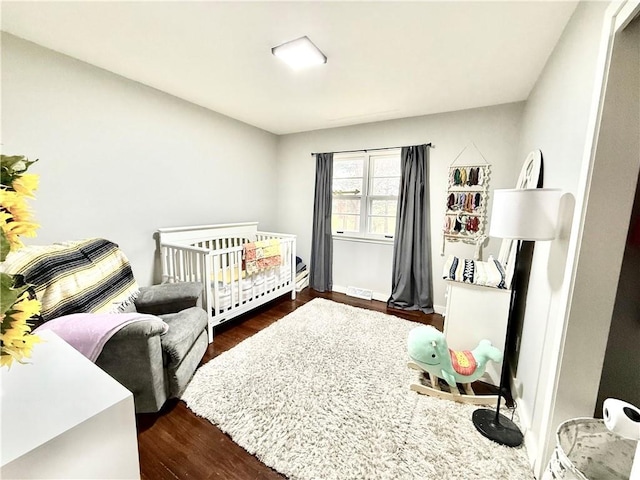 bedroom featuring dark wood finished floors and visible vents