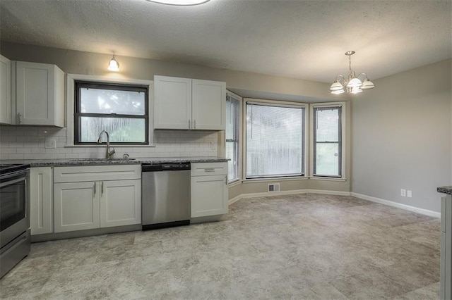 kitchen with stainless steel appliances, plenty of natural light, a notable chandelier, and a sink