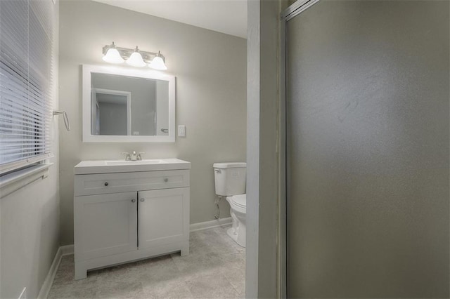 bathroom featuring baseboards, toilet, and vanity