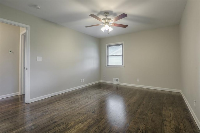 unfurnished room with baseboards, visible vents, a ceiling fan, and dark wood-style flooring