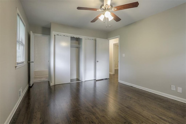unfurnished bedroom featuring a closet, dark wood-type flooring, a ceiling fan, visible vents, and baseboards