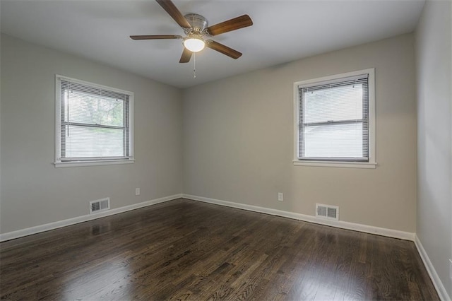 unfurnished room featuring baseboards, visible vents, ceiling fan, and dark wood-type flooring