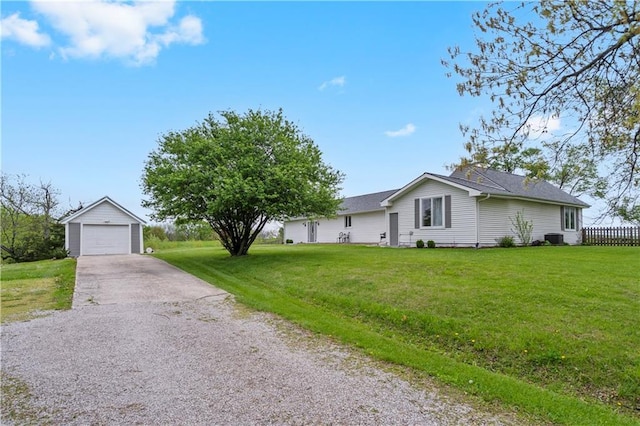 single story home featuring a front lawn, aphalt driveway, an outbuilding, and a detached garage
