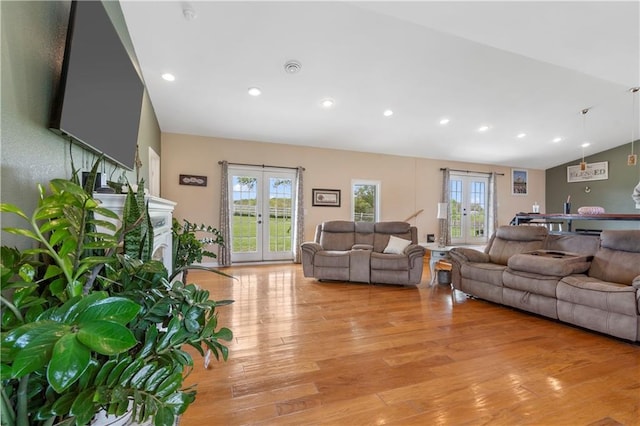 living area with french doors, recessed lighting, light wood-style flooring, and a healthy amount of sunlight