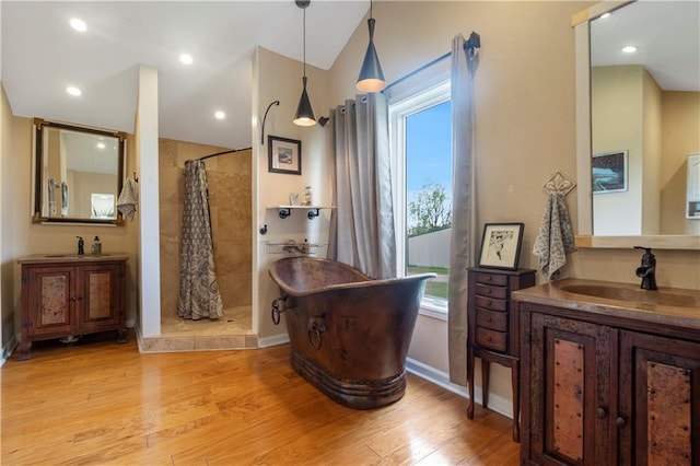 full bathroom featuring a soaking tub, tiled shower, a healthy amount of sunlight, and wood finished floors