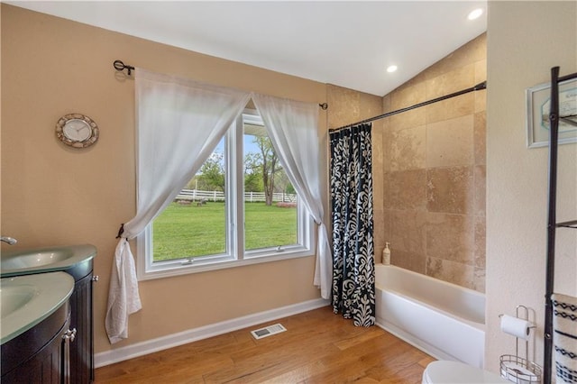 full bath featuring vanity, shower / bath combination with curtain, wood finished floors, lofted ceiling, and visible vents