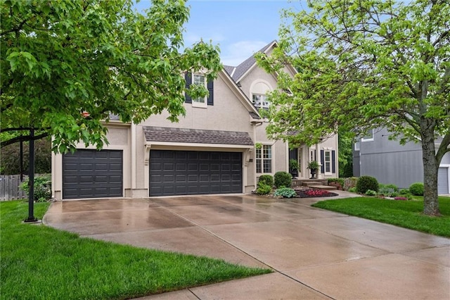 view of front of home with concrete driveway, stucco siding, a front lawn, and an attached garage