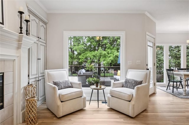 living area with light wood-style floors and ornamental molding