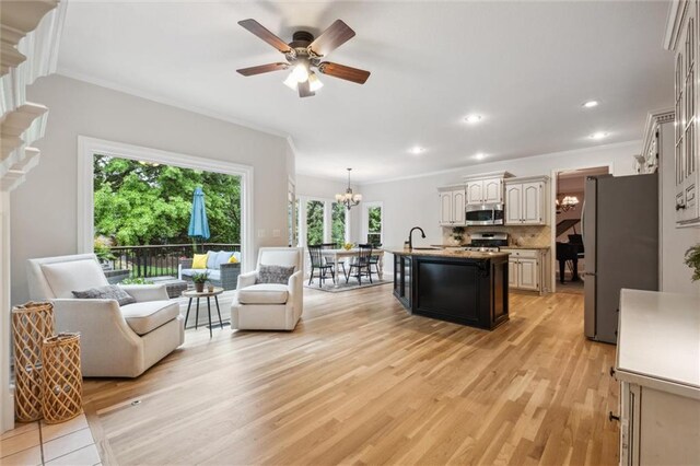 living room featuring ornamental molding, a chandelier, light wood-style flooring, ceiling fan, and recessed lighting