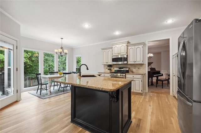 kitchen with appliances with stainless steel finishes, a chandelier, a sink, crown molding, and backsplash