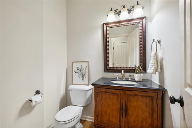 bathroom featuring toilet, vanity, and baseboards